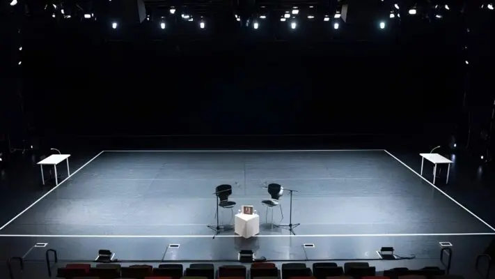 Darkened Empty Theater stage with two chairs in the center