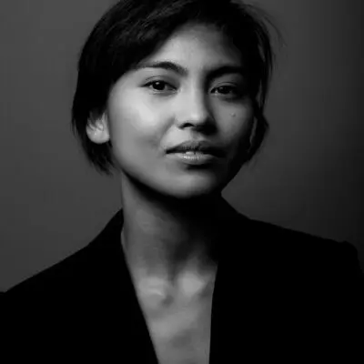 Black and white portrait photo of Marie Lloyd Paspe. They are facing the camera wearing a black sportscoat.